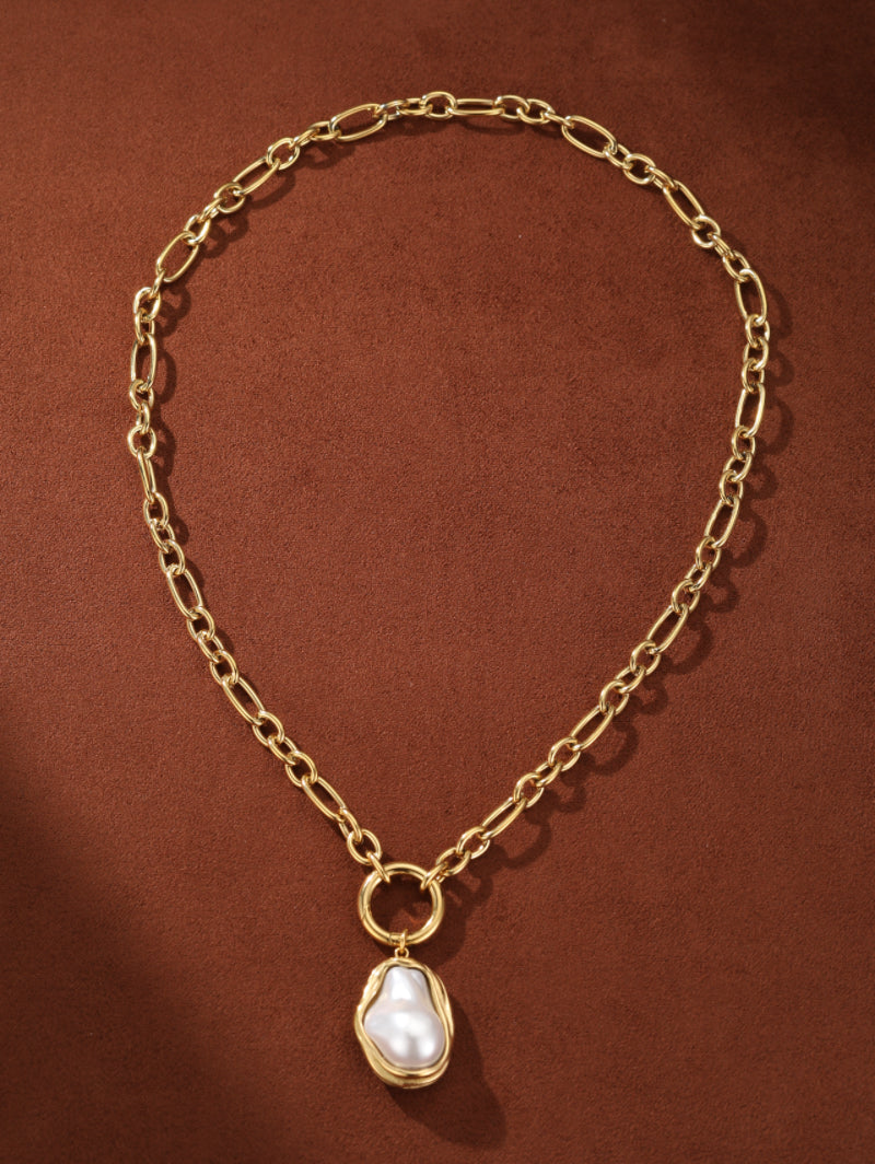 Golden Tide necklace with a chunky gold chain and a large, irregular white freshwater pearl pendant set in a gold-toned fluid frame. @pearl