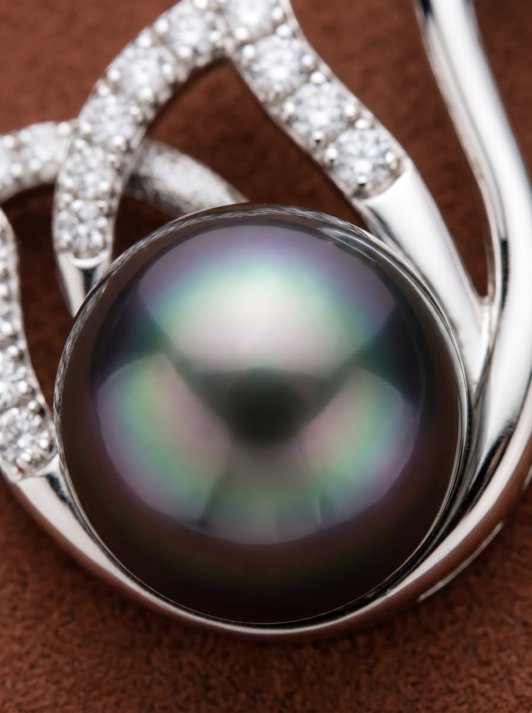 Close-up of a Graceful Tahitian Pearl Swan Drop Necklace, showcasing a large, lustrous black pearl cradled by a silver-tone swan pendant adorned with accent stones. @pearl
