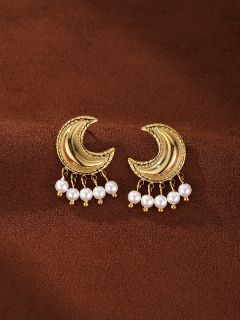 Halcyon gold-toned crescent moon drop earrings featuring five dangling white freshwater pearls on each earring.