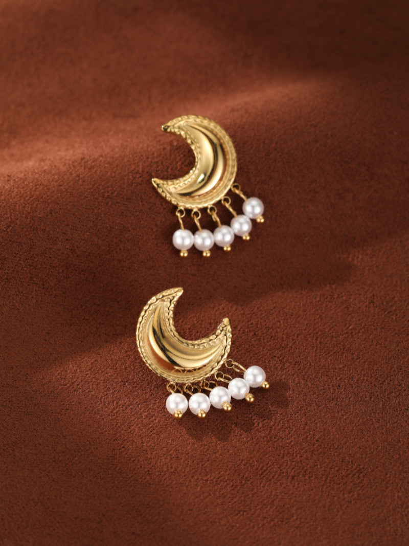 Halcyon gold-toned crescent moon drop earrings featuring five small white freshwater pearls dangling from the bottom.