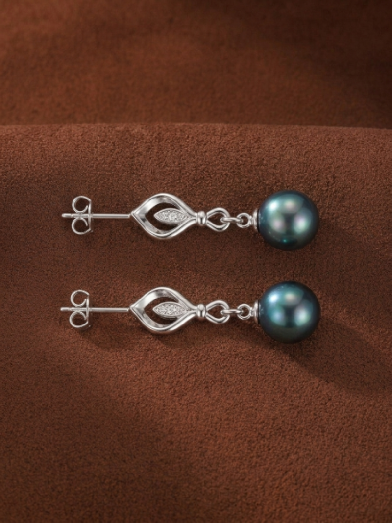 Ignis Tahitian pearl and diamond leaf drop earrings, featuring a stylized leaf motif with pavé diamonds suspended from a lustrous 10mm round Tahitian pearl.
