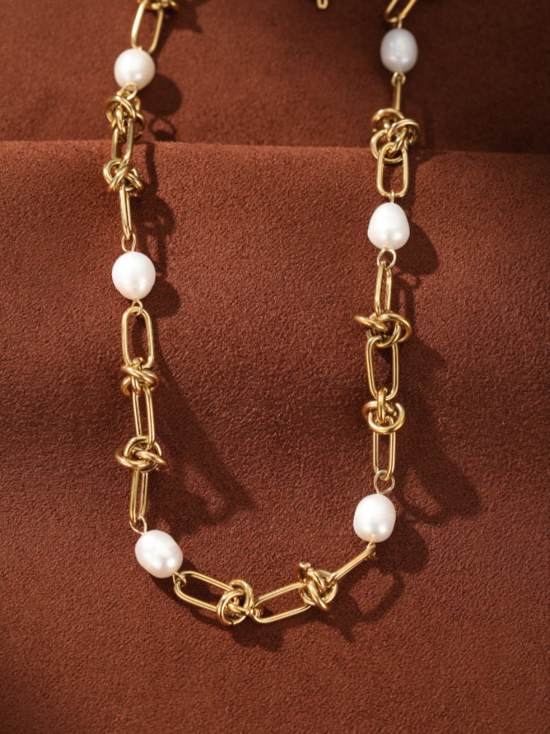 Gold-toned chain choker necklace featuring interspersed white freshwater drop pearls and unique knot details.@pearl