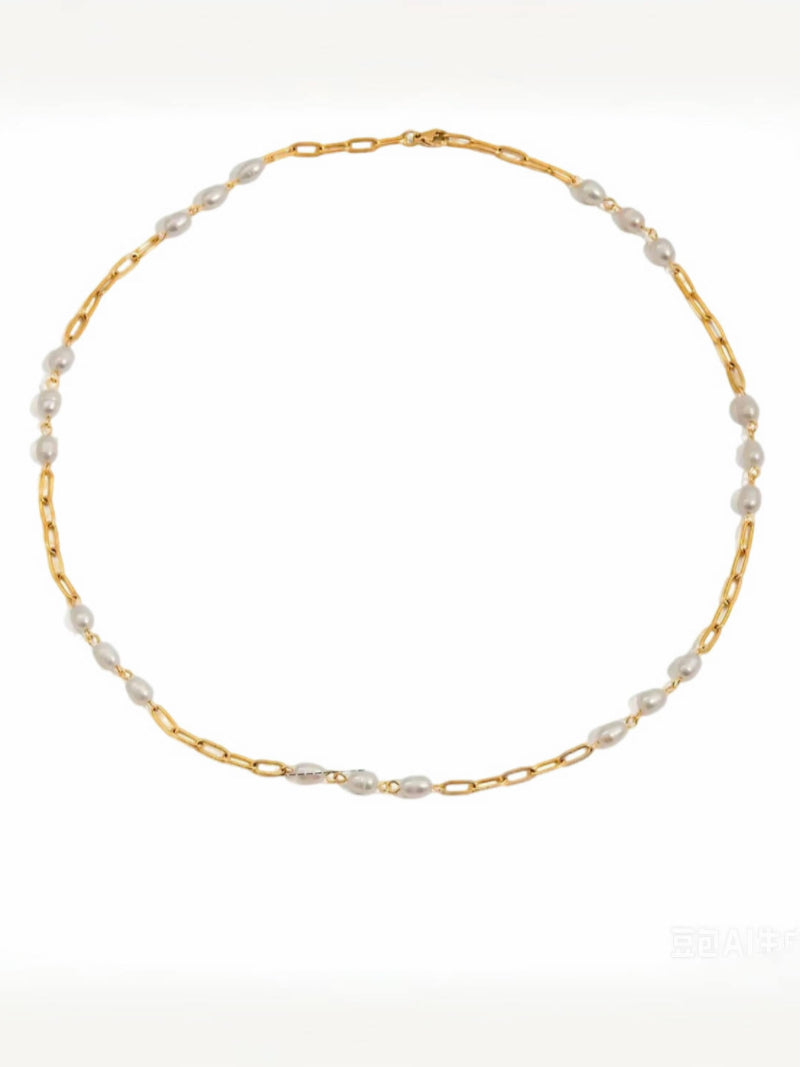 Lagoon Layers necklace featuring a gold-tone chain with alternating white freshwater seed pearls and elongated gold links.