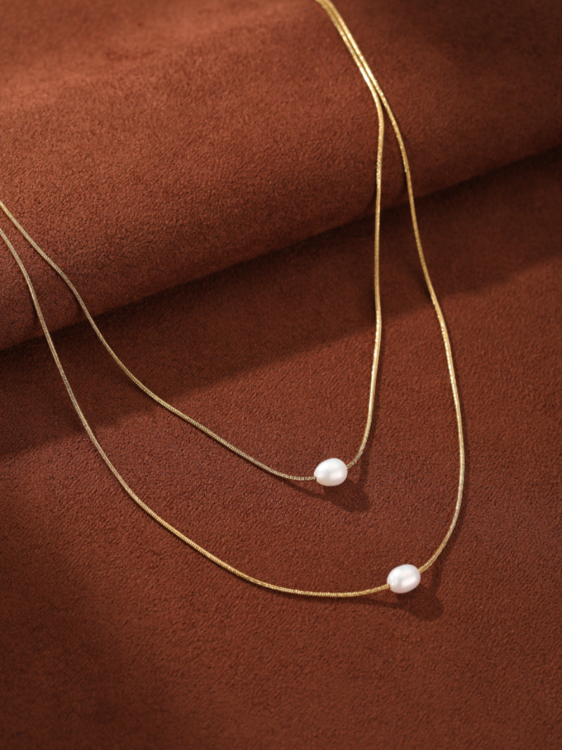 Layered gold-tone snake chains with floating freshwater baroque pearls