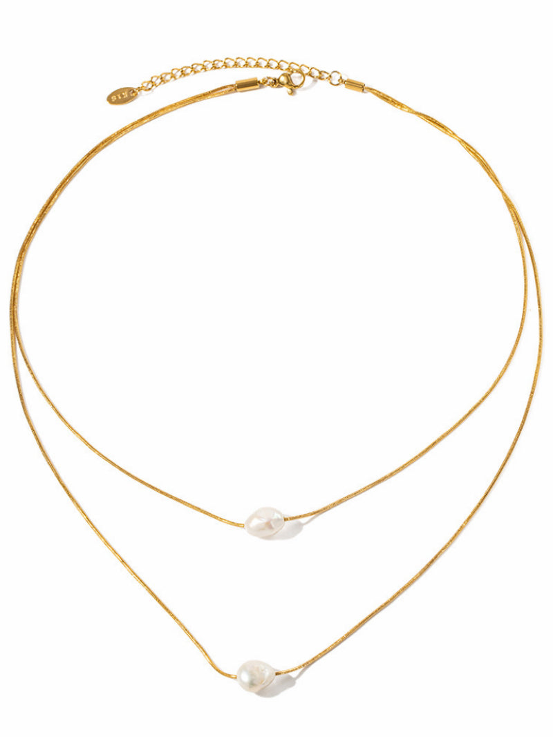A delicate, gold-tone layered necklace featuring two fine snake chains, each adorned with a single, floating white baroque freshwater pearl. The pearls have an organic, irregular shape, and the necklace has an adjustable clasp.