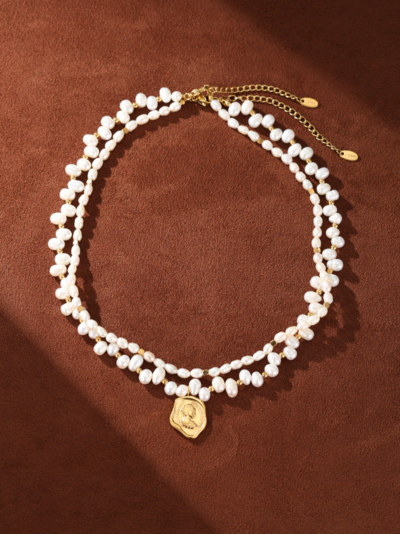 Collier pendentif perlé pièce Mythos en perle d'eau douce présentant deux rangs de perles graines de 5 mm avec un pendentif pièce doré.