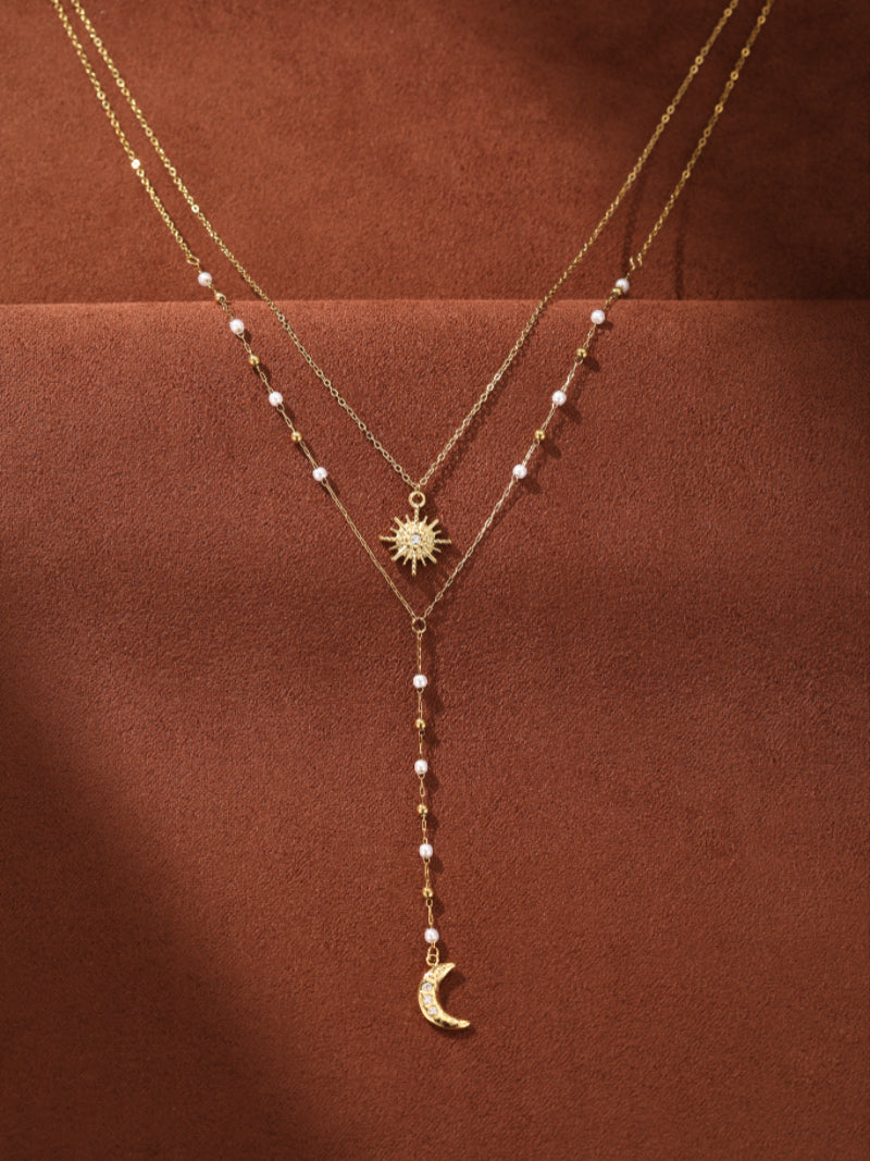 Nova - Freshwater Pearl Sun and Moon Long Layered Necklace featuring delicate gold-toned chains with small white pearls, a sparkling sun pendant, and a crescent moon charm. @pearl