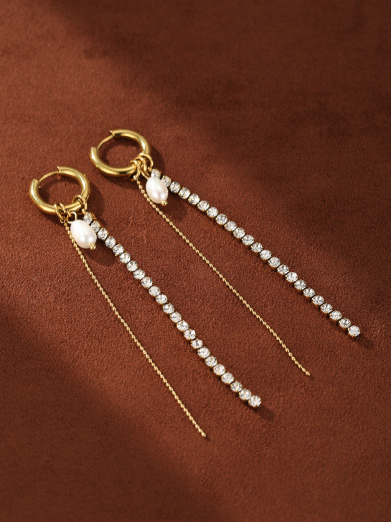 Prism dangle earrings featuring a gold hoop, a white freshwater pearl, and a cascading line of clear crystals with a delicate gold chain.