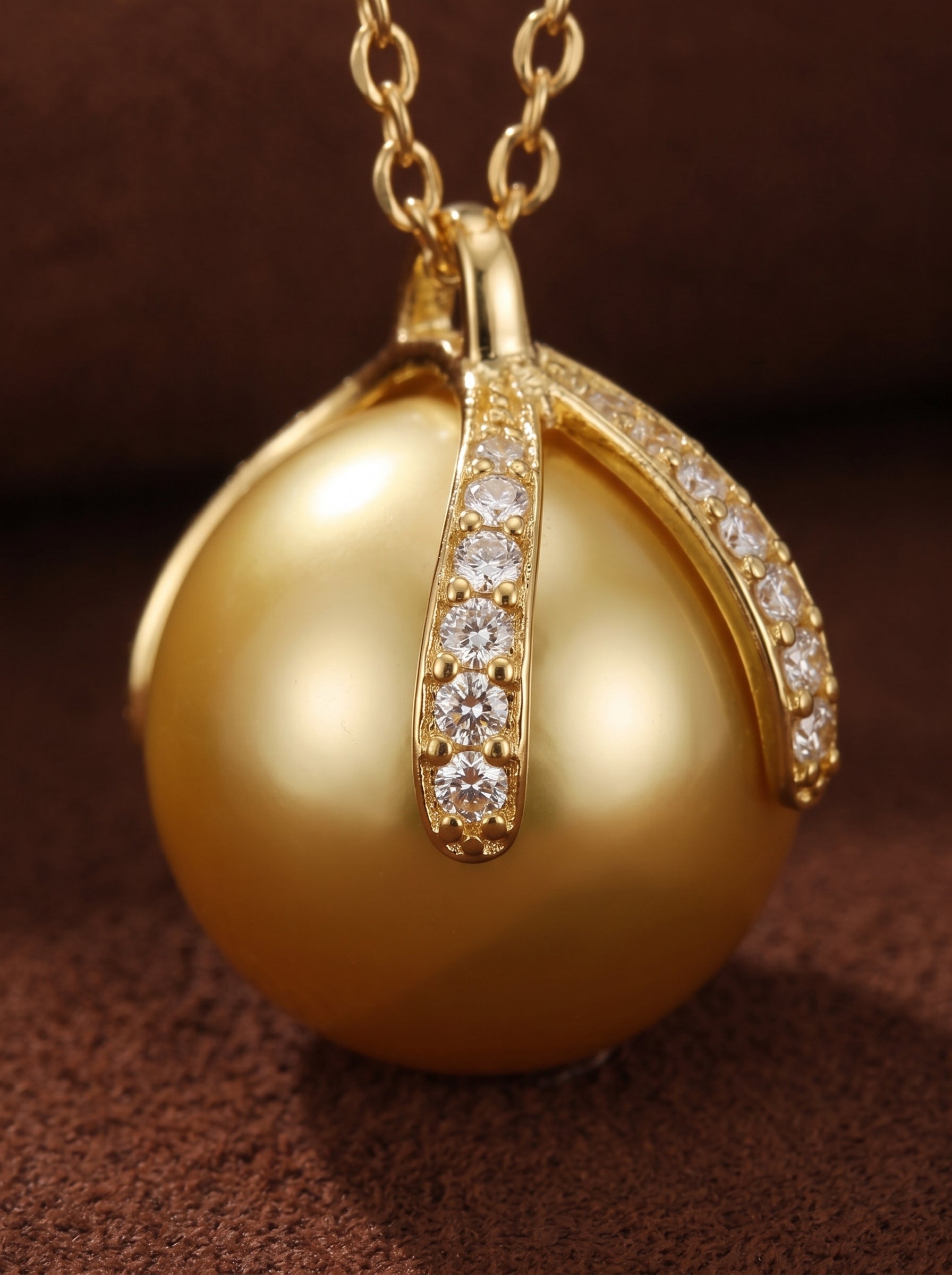 Solara - South Sea Pearl Pendant Necklace featuring a lustrous 12mm golden pearl set in a polished gold-tone pendant with sparkling gemstone accents on the bail. @pearl
