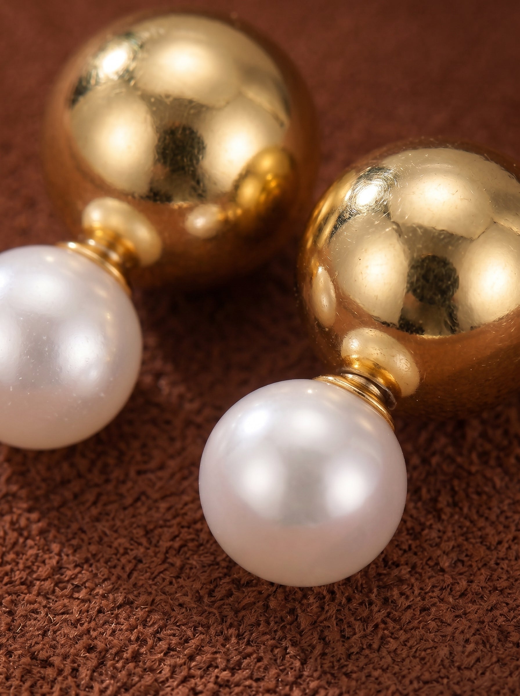 Sphere stud earrings featuring a polished gold-toned sphere attached to a luminous 10mm white freshwater pearl. @pearl