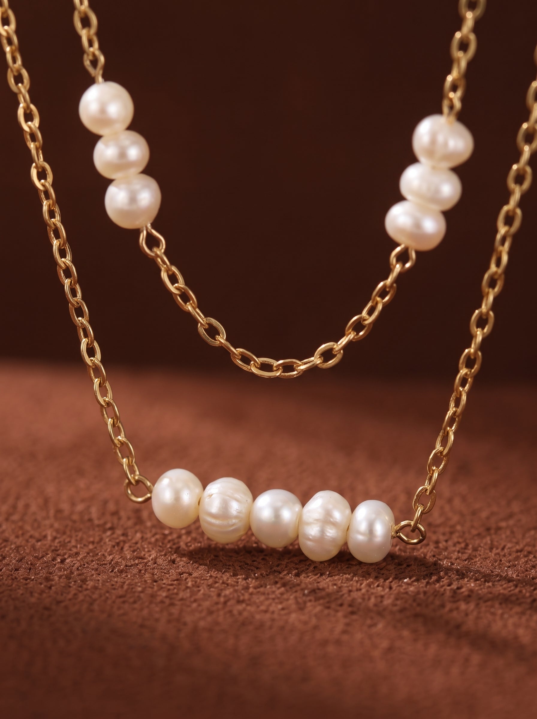 Stellaris double-strand necklace featuring small, luminous white freshwater button pearls spaced along delicate gold-toned chains. @pearl