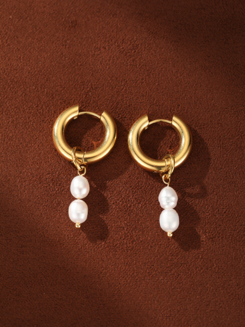 Paire de boucles d'oreilles goutte créoles imposantes ton or, chacune présentant deux perles graines blanches d'eau douce pendantes en dessous.