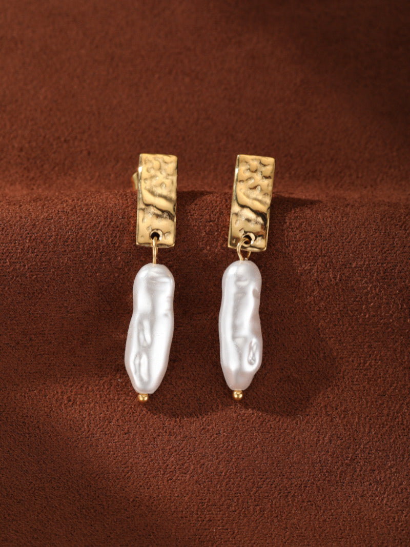 Boucles d'oreilles goutte en perle d'eau douce Terra présentant des puces rectangulaires martelées ton or et des gouttes de perle baroque blanche irrégulières d'eau douce.