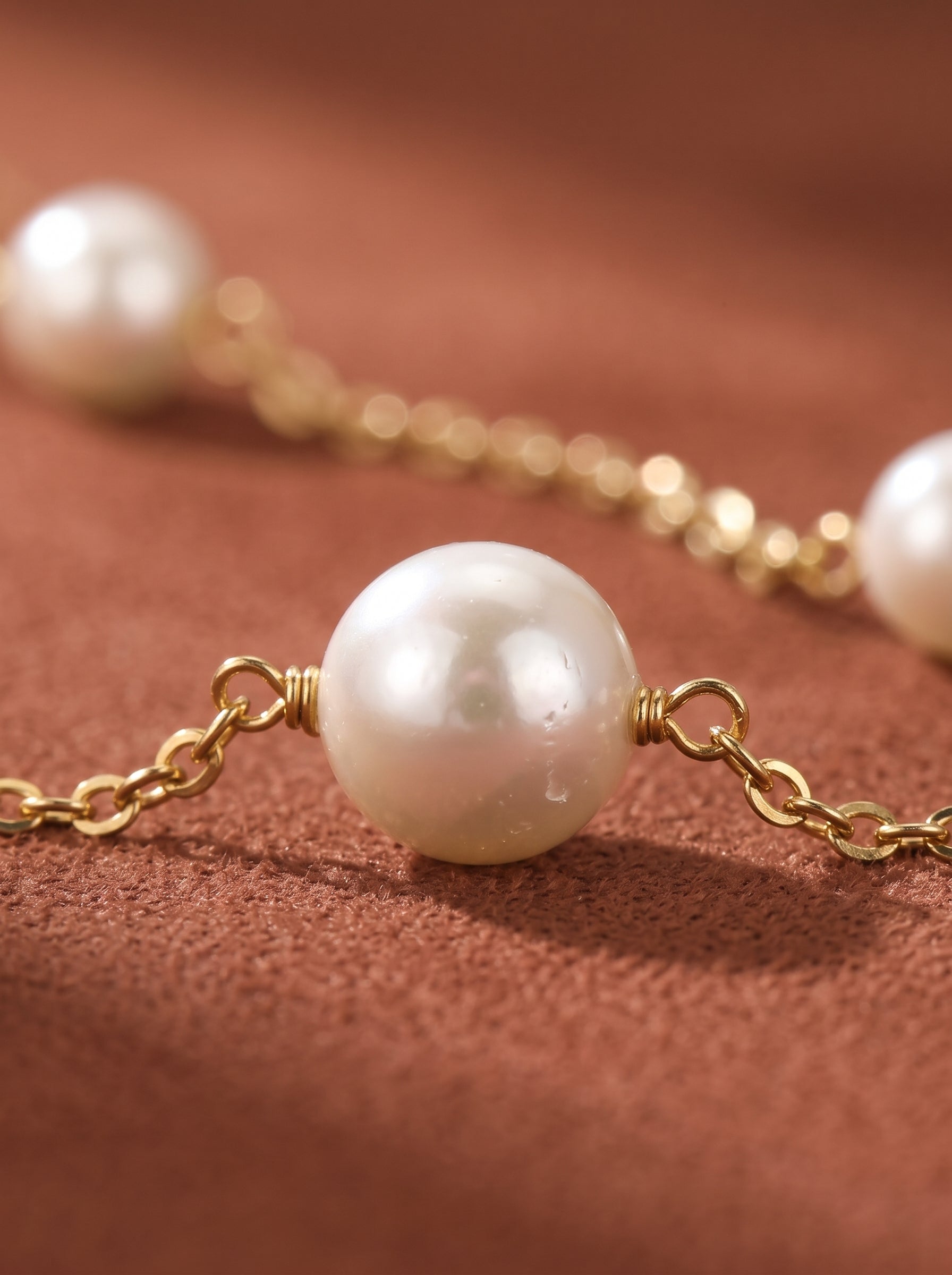 Close-up of a delicate gold chain bracelet adorned with luminous white freshwater pearls, showcasing the craftsmanship and elegant design. @pearl