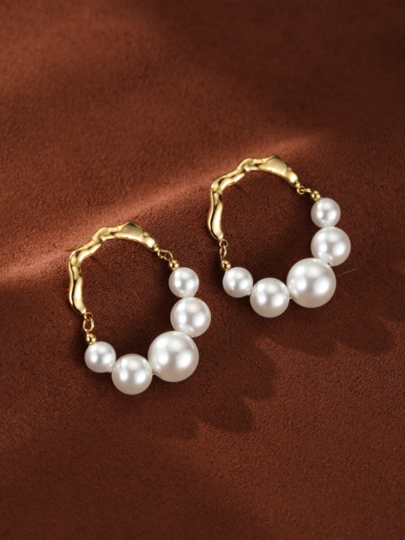 Créoles ondulées ton or Undine présentant des perles blanches graduelles d'eau douce allant de 4 mm à 8 mm.