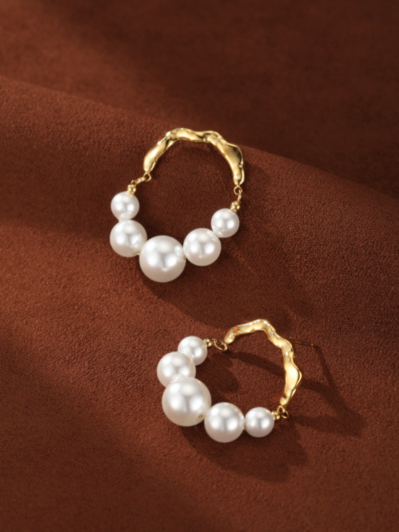 Créoles ondulées ton or Undine présentant des perles blanches graduelles d'eau douce de 4 mm à 8 mm.