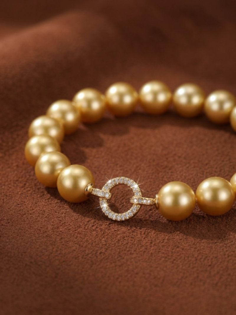 A bracelet featuring a strand of lustrous golden freshwater pearls, connected by a circular clasp encrusted with small diamonds.