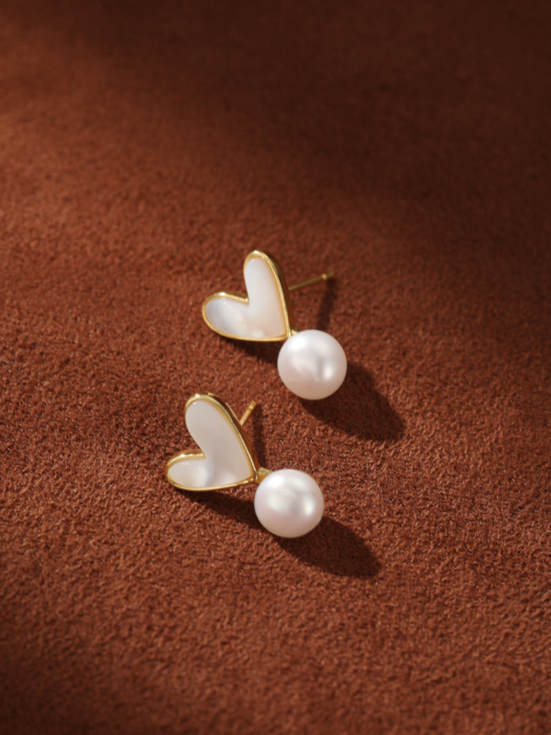 Vista Freshwater Pearl Heart Drop Earrings feature a white heart-shaped shell inlay with a gold border and a dangling luminous white freshwater pearl. @pearl