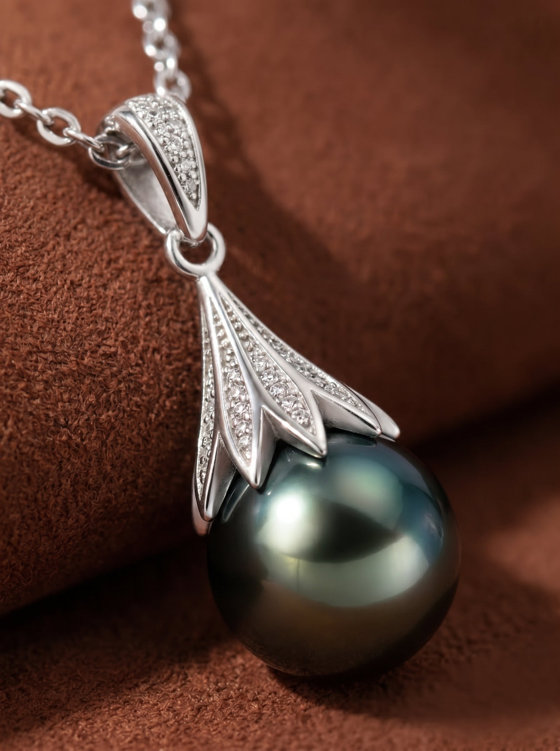 Close-up of the Vortex Tahitian Pearl Drop Necklace, showcasing a lustrous 10mm round black pearl suspended in a silver setting adorned with pavé-set diamonds, attached to a delicate chain. @pearl